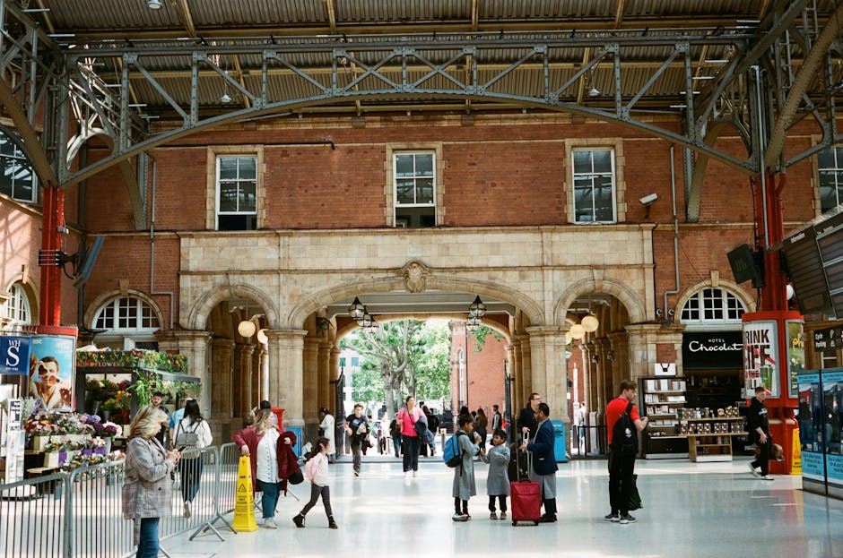 A street scene in Marylebone showing a red brick building with arched doorways and large windows, adjacent to a cobbled pavement marked with red and white lines indicating a no-loading zone. Several p